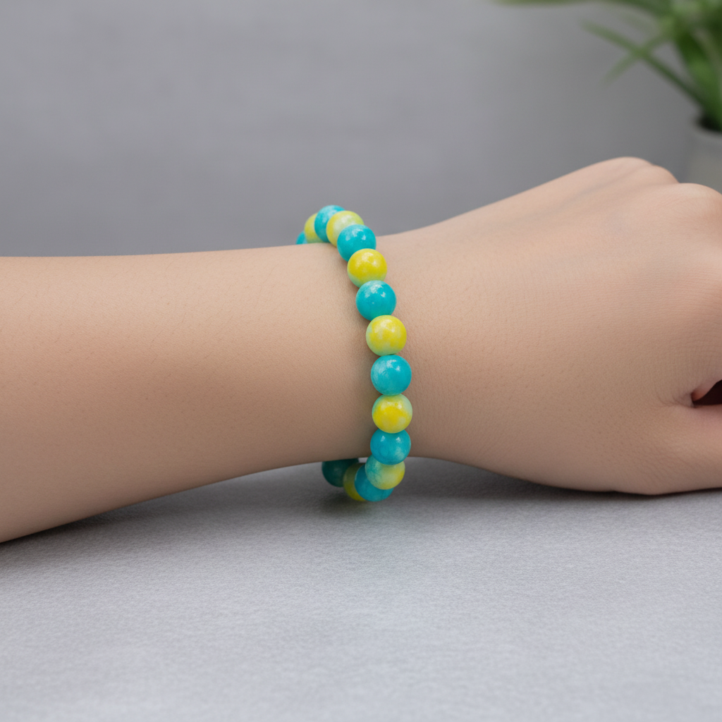 A beaded bracelet made of round turquoise-blue and yellow marbled beads, displayed on a wooden circular measuring stand marked 6 in.