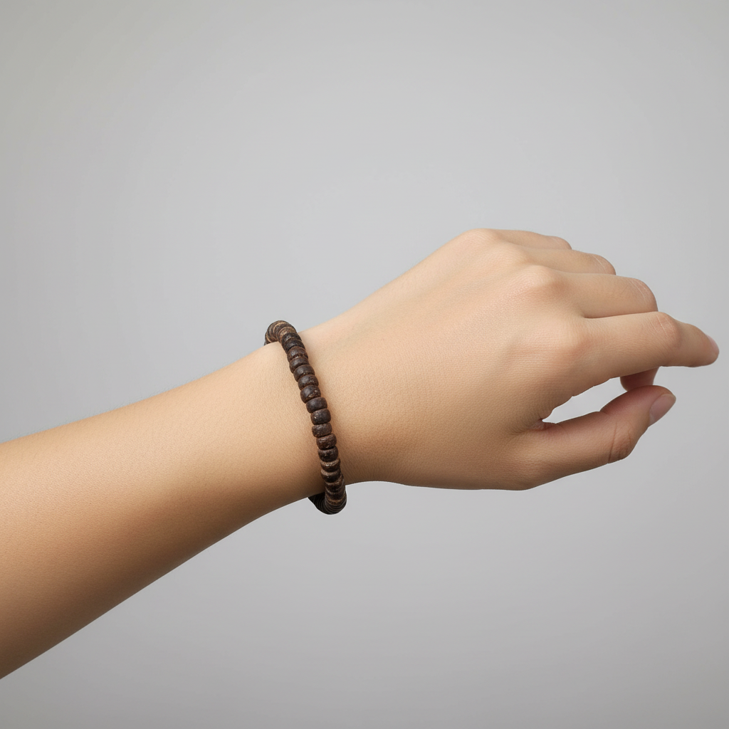 A beaded bracelet made of dark brown wooden beads, shown coiled on a light wood circular measuring insert marked '6in' for size reference.