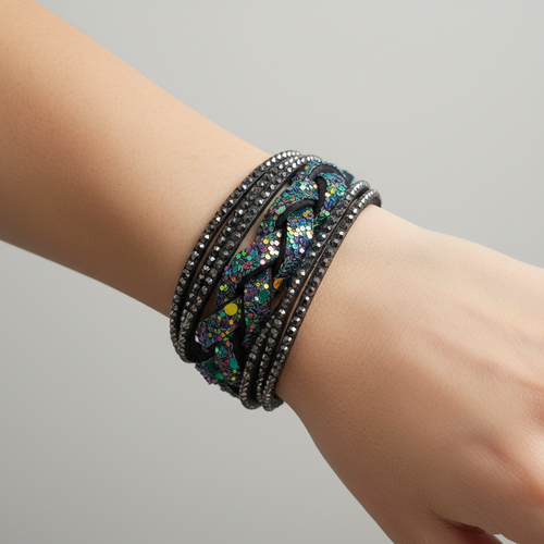 A stack of black wrap bracelets, including one with silver rhinestone bands and one with a colorful sequin pattern, displayed on a light wood surface.